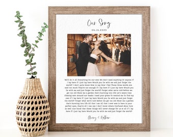 May include: A framed print with a black and white photo of a couple dancing at their wedding. The print has a white background with black text that reads "Our Song" and "04.14.2023". The text below the photo is a love poem.