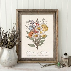May include: A framed floral print featuring a bouquet of daisies, roses, and other flowers in shades of white, yellow, orange, and blue. The print is set against a cream-colored background and framed in rustic wood. Text at the bottom reads "Grandma's Garden."