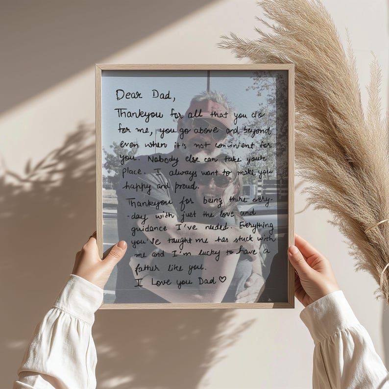 Puede incluir: Un marco de madera rectangular que contiene una fotograf&iacute;a de dos personas abraz&aacute;ndose, superpuesta con texto escrito a mano en negro que dice: Dear Dad, Thank you for all that you do for me, you go above and beyond even when it's not convenient for you.