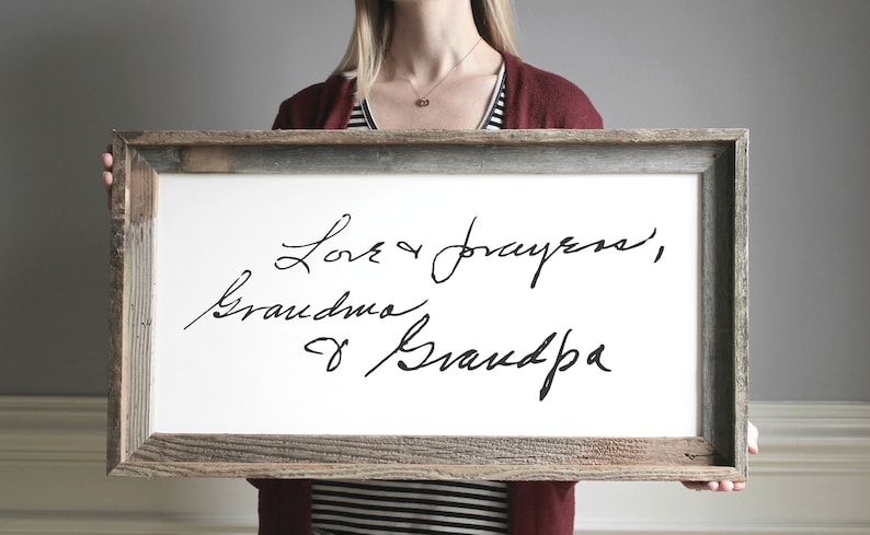 May include: A framed white canvas with black handwritten text that reads "Love & prayers, Grandma & Grandpa".
