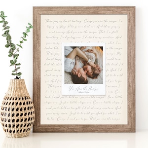 May include: A framed print with a handwritten love letter and a Polaroid photo of a couple embracing. The text reads "You are the reason" and is signed "Adam + Emma".