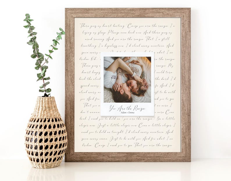 May include: A framed print with a handwritten love letter and a Polaroid photo of a couple embracing. The text reads "You are the reason" and is signed "Adam + Emma".