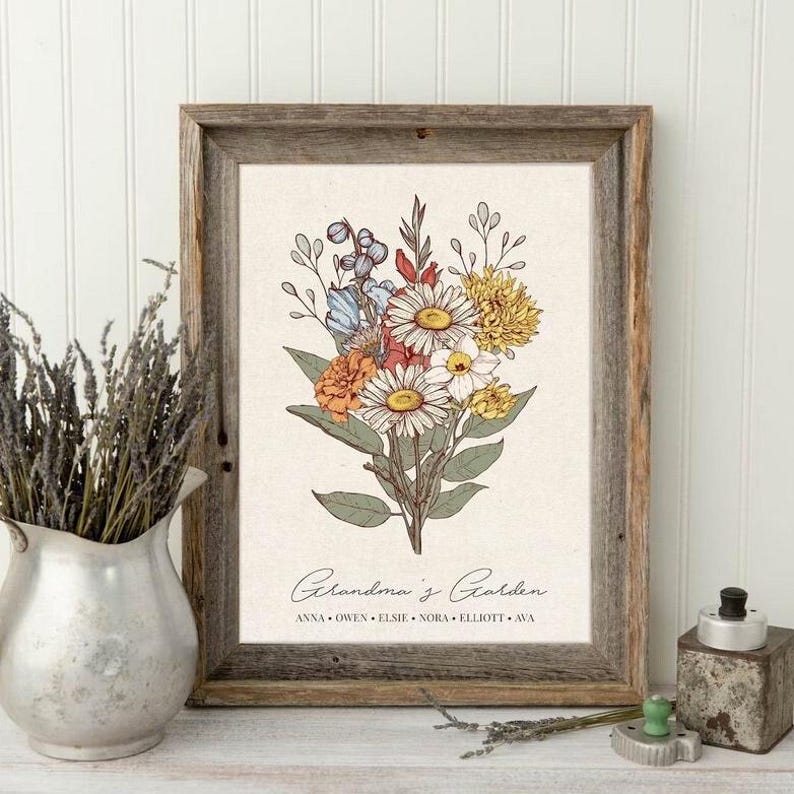 May include: A framed floral print featuring a bouquet of daisies, roses, and other flowers in shades of white, yellow, orange, and blue. The print is set against a cream-colored background and framed in rustic wood. Text at the bottom reads "Grandma's Garden."
