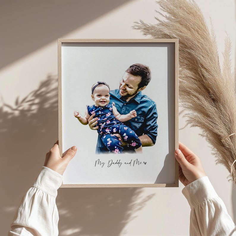 May include: A framed photo of a father and daughter. The father is holding the daughter in his arms. The daughter is wearing a pink and blue floral dress. The photo is captioned "My Daddy and Me".