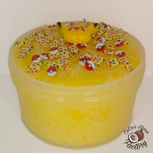 May include: Yellow slime with a Pikachu figurine on top. The slime is topped with red and yellow Pokeball and Pikachu sprinkles.