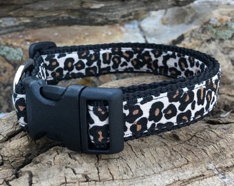 May include: A black and white leopard print dog collar with a black plastic buckle.