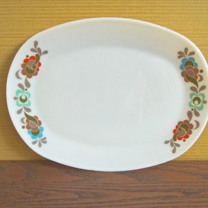 Peut inclure: Plat ovale blanc avec un motif floral dans les tons de rouge, marron, bleu et vert. Le motif d&eacute;coratif est sur les c&ocirc;t&eacute;s gauche et droit du plat. Le plat de service est en c&eacute;ramique.