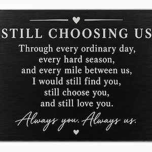 May include: A rectangular black metal card with a brushed finish featuring silver engraved text that reads: STILL CHOOSING US, Through every ordinary day, every hard season, and every mile between us, I would still find you, still choose you, and still love you. Always you. Always us.