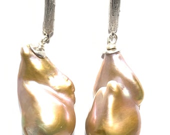 May include: A pair of silver earrings with a branch-like design and a large, irregular, iridescent pearl drop on each earring.