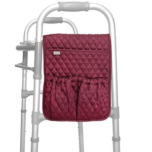 May include: A burgundy quilted walker bag with a diamond pattern. The bag has a top pocket and two lower pockets with gathered openings. It is attached to a silver walker frame.