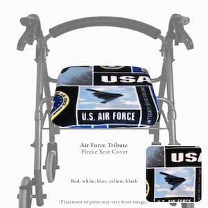 Puede incluir: Una funda de asiento de forro polar para andador con un dise&ntilde;o de la Fuerza A&eacute;rea de EE. UU. en negro, azul, blanco y amarillo. La tela muestra im&aacute;genes de aviones militares, el texto U.S. AIR FORCE y USA en un patr&oacute;n de bloques.