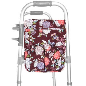 May include: A floral patterned walker bag with multiple pockets. The bag is attached to a walker with a silver frame.