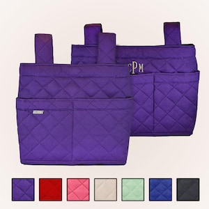Pode incluir: Dois organizadores de armazenamento em tecido acolchoado roxo com alças para pendurar. A frente apresenta dois bolsos e uma pequena etiqueta prateada com a inscrição C-Me. O organizador traseiro exibe o monograma bordado CPM em fio dourado. Abaixo estão sete amostras de cores.