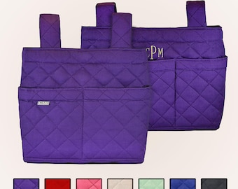 Pode incluir: Dois organizadores de armazenamento em tecido acolchoado roxo com alças para pendurar. A frente apresenta dois bolsos e uma pequena etiqueta prateada com a inscrição C-Me. O organizador traseiro exibe o monograma bordado CPM em fio dourado. Abaixo estão sete amostras de cores.