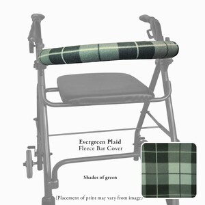 Pode incluir: Um andarilho apresenta uma capa de barra em tecido polar com padr&atilde;o xadrez em tons de verde. A capa cil&iacute;ndrica envolve a barra frontal horizontal do auxiliar de mobilidade preto. O texto diz Evergreen Plaid Fleece Bar Cover.