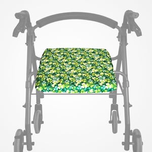 May include: A walker seat cushion featuring a pattern of green and yellow clovers. The cushion is rectangular and designed to fit a walker frame. The clover design uses various shades of green and yellow.