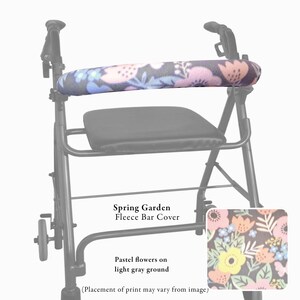 Pode incluir: Um andarilho preto com uma capa de barra em fleece com um padr&atilde;o floral de flores pastel cor-de-rosa, amarelas e azuis sobre um fundo cinzento escuro. O texto Spring Garden Fleece Bar Cover e Pastel flowers on light gray ground &eacute; vis&iacute;vel.
