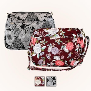 Może przedstawiać: Dwie torebki crossbody w kwiaty. Jedna torebka jest czarno-biała z kwiatowym wzorem. Druga torebka jest bordowa z kwiatowym wzorem w odcieniach różu, bieli i zieleni. Obie torebki mają pikowany design i regulowane paski.