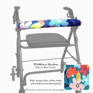 Pode incluir: Uma capa de barra em fleece Wildflower Meadow com um padr&atilde;o floral vibrante de flores cor-de-rosa, laranja, azuis, amarelas, brancas e vermelhas sobre um fundo azul, fixada na barra de suporte horizontal de um andarilho de metal preto com assento.