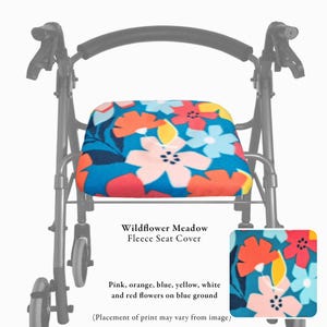 Puede incluir: Una funda de asiento de forro polar para andador con estampado Wildflower Meadow de flores rosas, naranjas, azules, amarillas, blancas y rojas sobre fondo azul. La funda est&aacute; instalada en un marco de andador de metal negro.