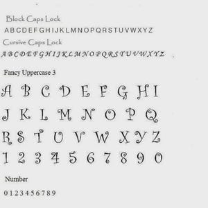 May include: A white sheet displays various font styles, including block, cursive, and fancy uppercase letters and numbers. The fonts are in black, showcasing different design options for text.