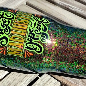 May include: A green and gold tumbler with glitter and the text "She's got mad hustle and a pretty cool vibe".