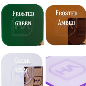 May include: A display of acrylic samples labeled Newest Acrylic Colors. The squares include Frosted Green, Frosted Amber, and Clear Lilac. Each piece features a logo with the letters HA inside a square outline, and some have a brown protective backing.