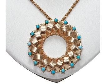 Teal blue turquoise & 14 karat yellow gold fancy three dimensional circle design pendant.