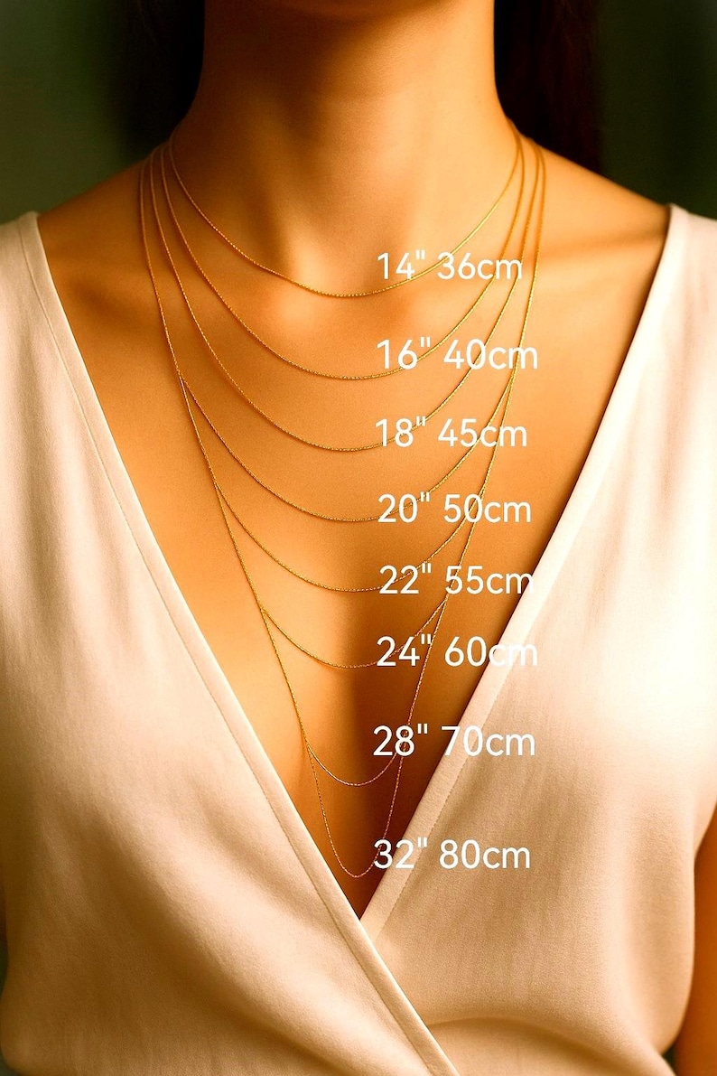 a close-up of a person's neck with multiple gold necklaces of varying lengths, each labeled with its corresponding size in centimeters.