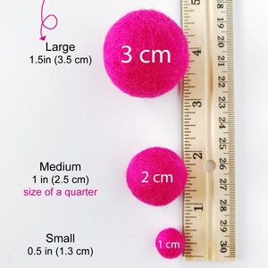 May include: Three pink felt balls of different sizes, measured against a ruler. The largest ball is 3 inches (3.5 cm) in diameter, the medium ball is 1 inch (2.5 cm) in diameter, and the smallest ball is 0.5 inches (1.3 cm) in diameter.