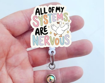 May include: White retractable badge holder with a colorful cartoon goose and the text "All of my systems are nervous".