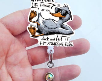 May include: A white retractable badge holder with a cartoon duck wearing sunglasses and the text "WHATEVER LIFE THROWS AT YOU, duck and let it HIT SOMEONE ELSE."