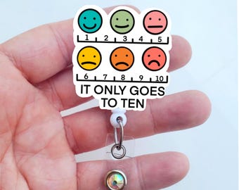 May include: A white plastic badge holder with a colorful smiley face scale from 1 to 10. The scale reads "It only goes to ten".