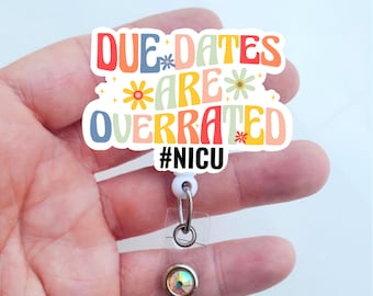Könnte beinhalten: Ein weißes Ausweis-Jojo mit einem bunten Aufkleber mit der Aufschrift "DUE DATES ARE OVERRATED #NICU". Der Aufkleber hat ein Retro-Design mit Blumen und einem Regenbogenfarbschema. Das Jojo hat einen transparenten Kunststoffriemen und einen dekorativen irisierenden Knopf.