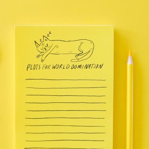 May include: Yellow notepad with black lines and the text "Plots for World Domination" at the top. A black and white illustration of a cat sleeping is above the text. A yellow pencil and a hole punch are on a yellow background.