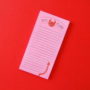 May include: A pink notepad featuring the text "EVIL PLANS" and a cartoon devil illustration. The notepad has lined pages and a red arrow graphic. Set against a solid red background.