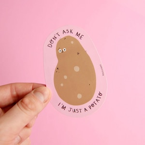 May include: A white sticker with a brown potato cartoon on it. The potato has a face and says "Don't ask me I'm just a potato".