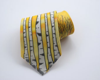 May include: A yellow silk tie with a pattern of white birch trees and black branches. The tie is rolled up and the pattern on the back of the tie shows a yellow field with black branches.