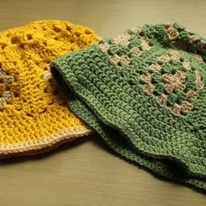 May include: Two crocheted sun hats, one yellow and one green, with a white crocheted design.