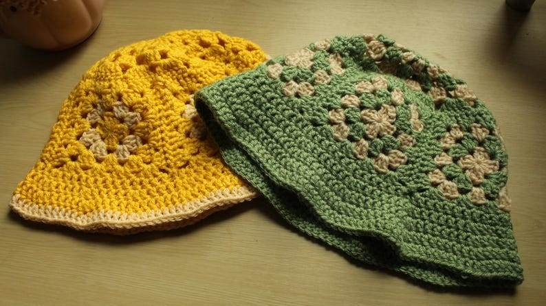 May include: Two crocheted sun hats, one yellow and one green, with a white crocheted design.