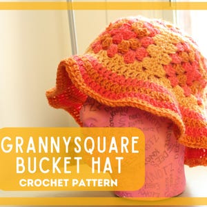 May include: A crochet bucket hat made with granny squares in shades of orange and pink. The hat is on a pink mannequin head. "Granny Square Bucket Hat Crochet Pattern" is written in white text on a yellow background.