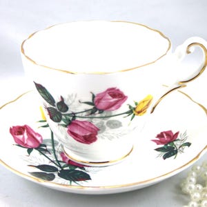 Taza de té y platillo Grosvenor, hermoso diseño de rosas sobre fondo blanco, bordes dorados, porcelana inglesa fabricada en la década de 1970.