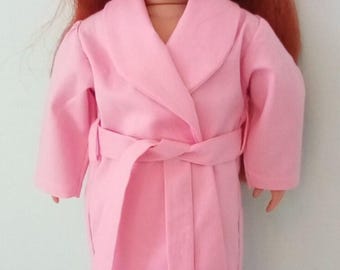 May include: A doll with red hair, freckles, and blue eyes, wearing a pink robe with a matching belt, polka dot pajama pants, a headband, and slippers. The doll is standing.