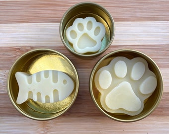 Bálsamo para patas y nariz totalmente natural, protege e hidrata. Varios tamaños y formas para gatos y perros. Barra de loción en lata reutilizable con tapa de rosca dorada.