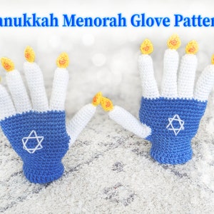 May include: Two crocheted gloves shaped like hands, each with five fingers. The fingers are white and topped with yellow flames, resembling a menorah. The gloves are blue at the wrist with a white Star of David.
