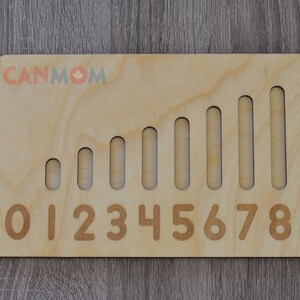May include: Wooden number learning toy with ten slots and corresponding numbers 0-9. The slots increase in size to represent the increasing value of each number.