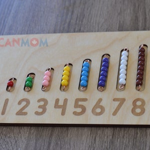 May include: Wooden counting board with rows of colorful beads representing numbers 1 through 9. The board has the numbers 0 through 9 printed on it.