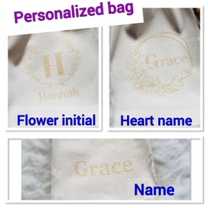 K&ouml;nnte beinhalten: Drei wei&szlig;e Stofftaschen mit verschiedenen Personalisierungsoptionen. Die erste Tasche hat einen Blumengirlanden mit dem Anfangsbuchstaben "H" und dem Namen "Hannah" darunter. Die zweite Tasche hat einen Blumengirlanden mit dem Namen "Grace" darin. Die dritte Tasche hat den Namen "Grace" in einer einfachen Schriftart gedruckt.