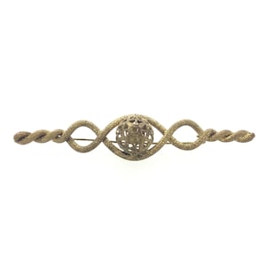 May include: A gold-toned brooch with a twisted wire design and a central decorative ball.