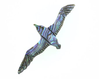 May include: A blue and green iridescent seagull sculpture made of abalone shell.
